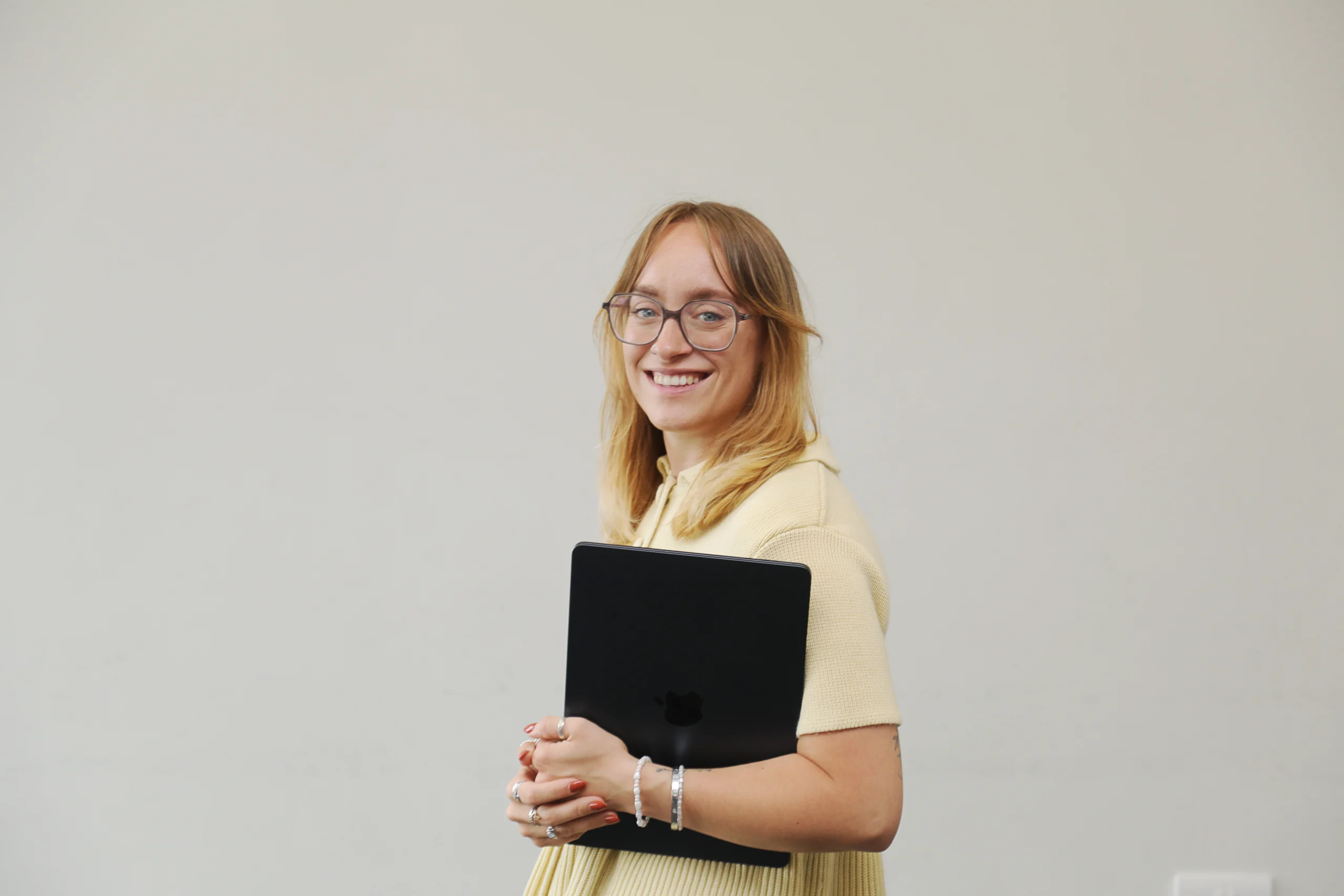 creative director standing with laptop smiling